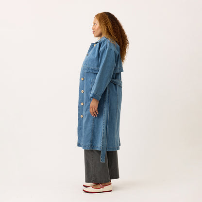 A side view of the Nancybird Linu Trench in Denim on a model on a blank background