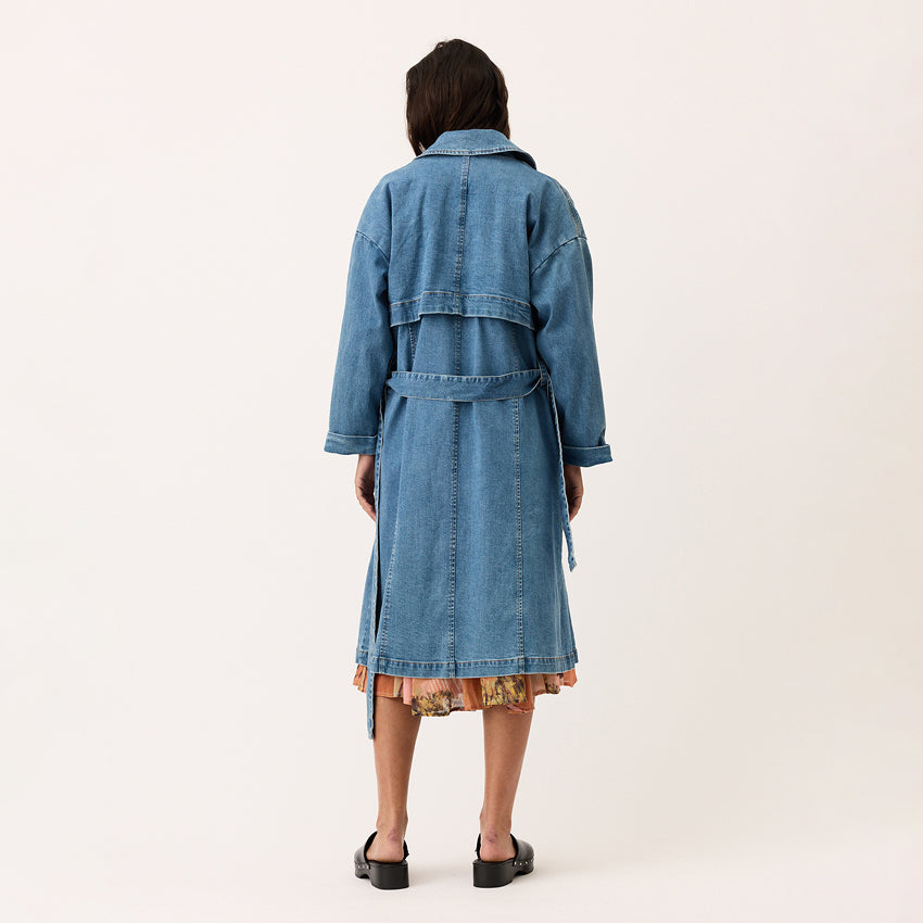 A back view of the Nancybird Linu Trench in Denim on a model on a blank background