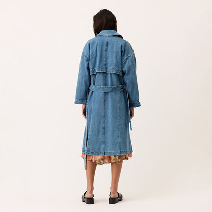 A back view of the Nancybird Linu Trench in Denim on a model on a blank background