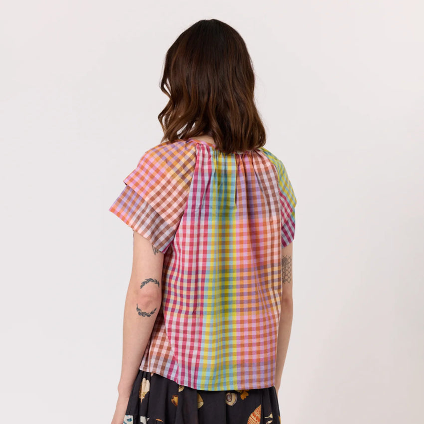 The back of the Nancybird Micci Top in Sunrise Check on a model on a blank background