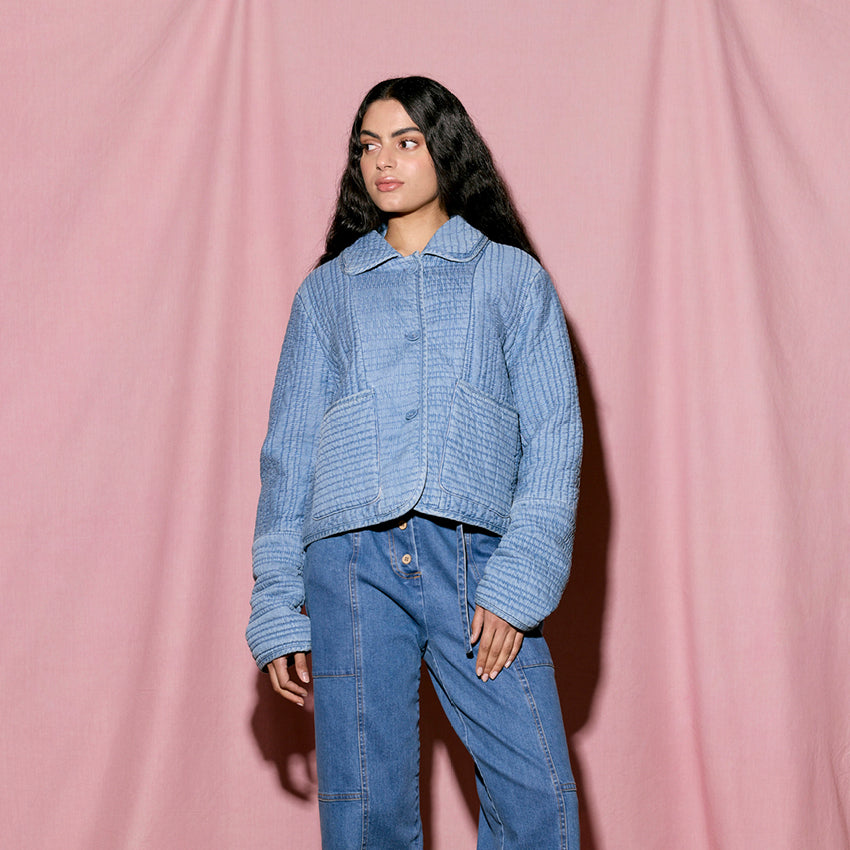 The Nancybird Nadia Quilted Jacket in Denim on a model on a pink background