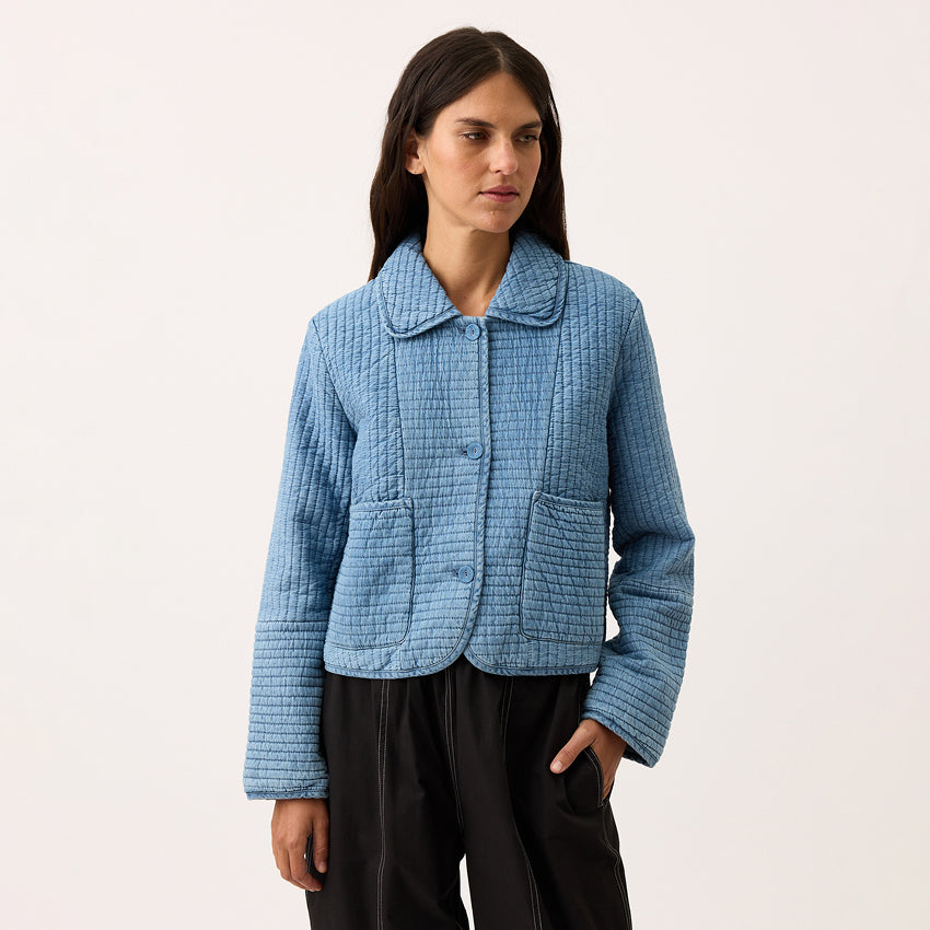 The Nancybird Nadia Quilted Jacket in Denim on a model on a blank background