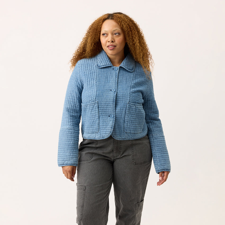 The Nancybird Nadia Quilted Jacket in Denim on a model on a blank background