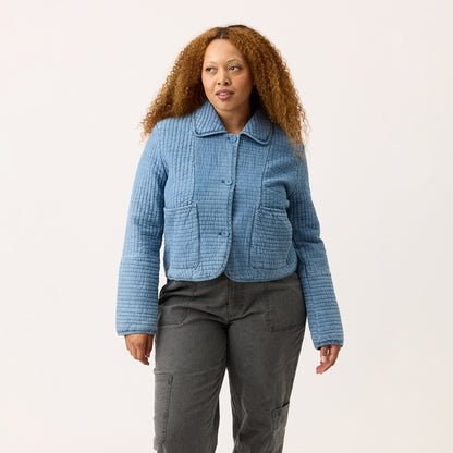 The Nancybird Nadia Quilted Jacket in Denim on a model on a blank background