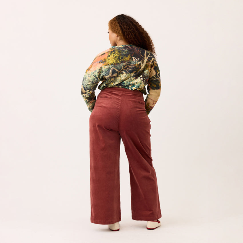 A back view of the Nancybird Niko Pants in Spice on a model on a blank background