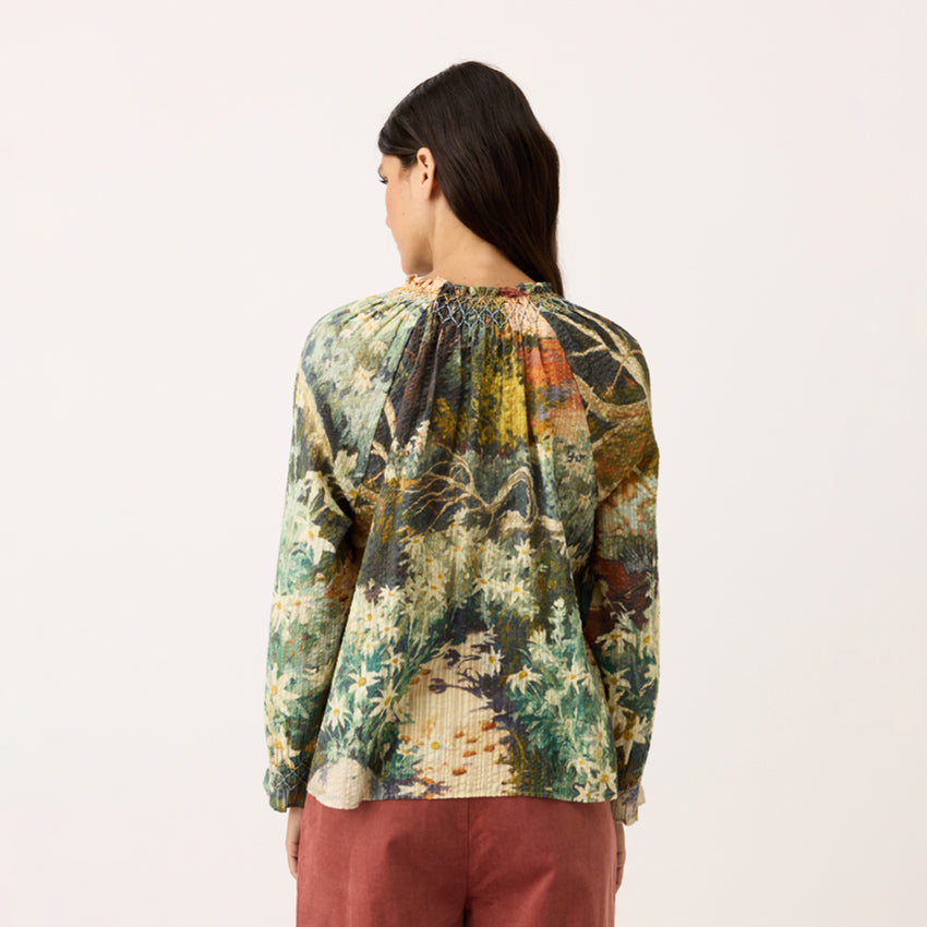 A back view of the Nancybird Rowena Shirred Blouse in Flannel Flower on a model on a blank background