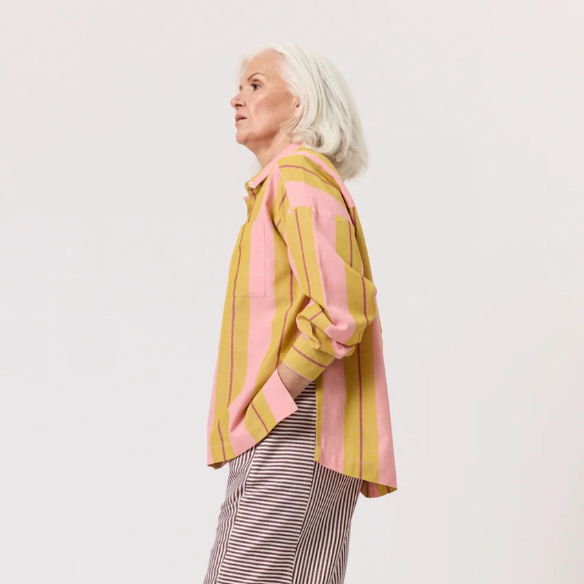 The side of the Nancybird Sabine Shirt in Dusk Stripe on a model on a blank background