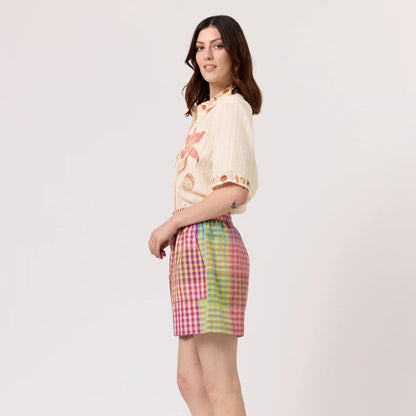 The side of the Nancybird Zana Shorts in Sunrise Check on a model on a blank background