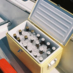 The Napoleon Goods Chilly Bin in Lemon Yellow with drinks and ice in it on a boat