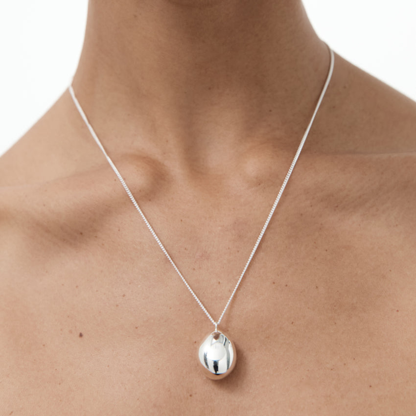 The Nina Gordon Drop Necklace in Sterling Silver on a models neck