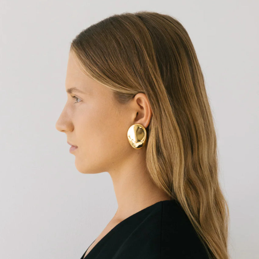 The Nina Gordon Dylan Dome Earrings in Gold on a model