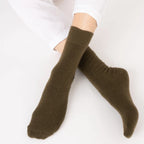 Person wearing Nooan Hamilton Possum and Merino Wool olive green socks on a white background