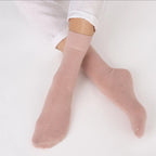 Rose Nooan Hamilton Possum and Merino Wool socks worn with white pants on a light gray background