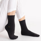 Person wearing black Nooan Hamilton Possum and Merino Wool socks on a white background