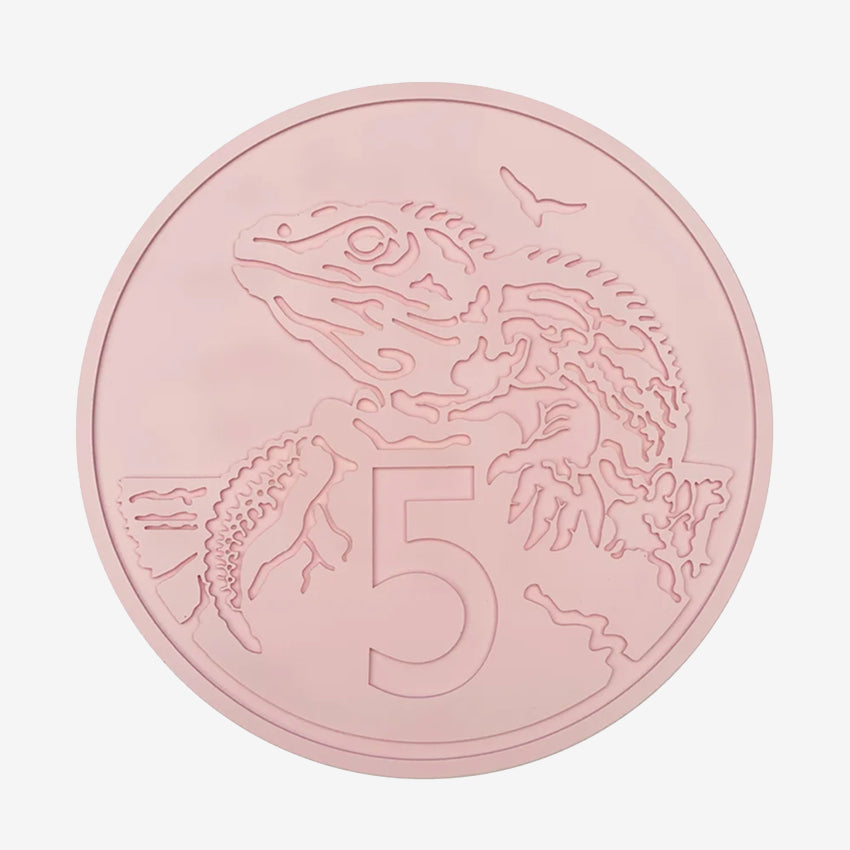 The One Lane Bridge 5 Cent Candy Coin in pink on a blank background