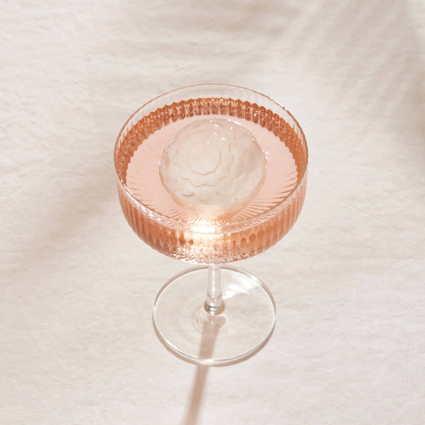 A Peak Petal Cocktail Ice in a cocktail glass with a drink