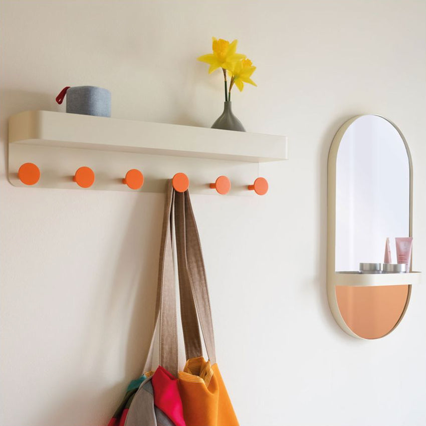 The Remember Wall Coat Rack in Cream on a wall with bags hanging off it and a speaker and vase sitting on top