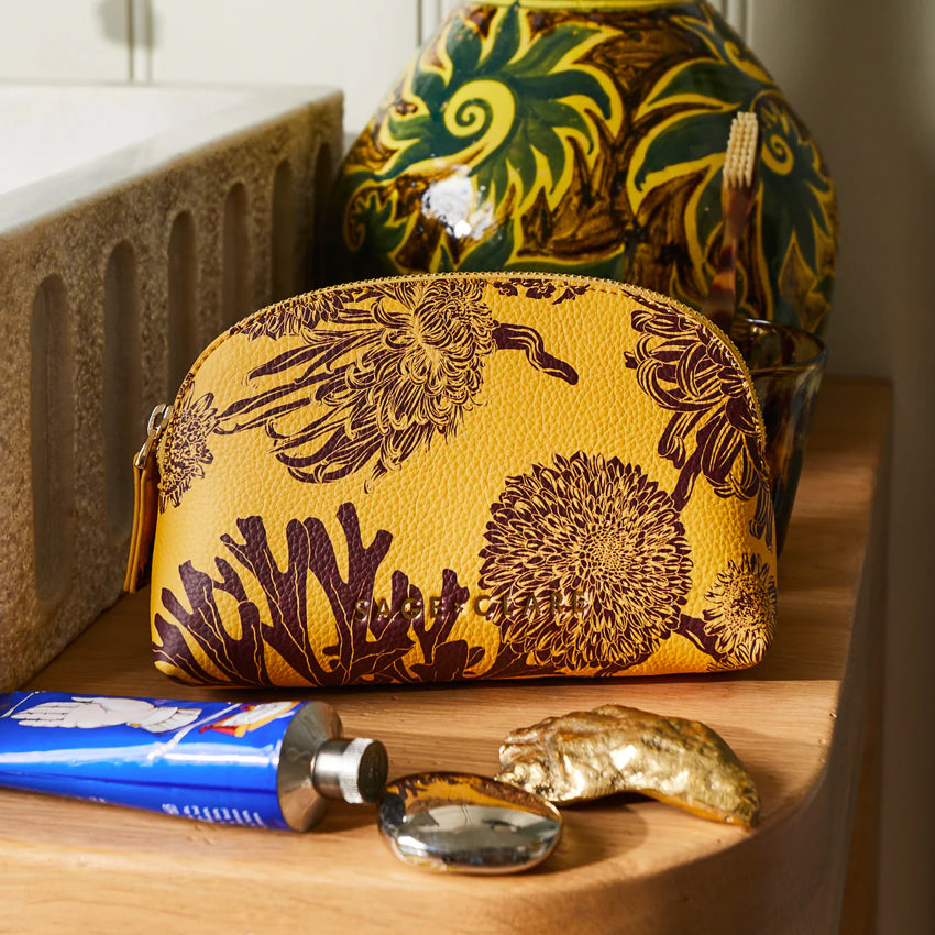 The Sage x Clare Delphine Cosmetic Pouch in Dune on a vanity 