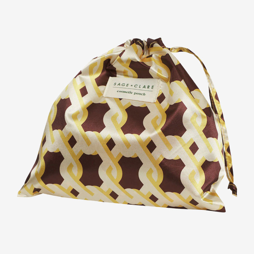 The bag for the Sage x Clare Delphine Cosmetic Pouch in Dune on a grey background