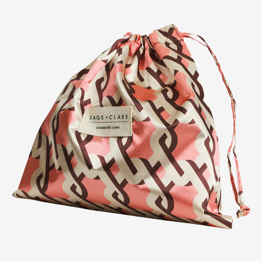 The bag for the Sage x Clare Delphine Cosmetic Pouch in Garnet on a grey background