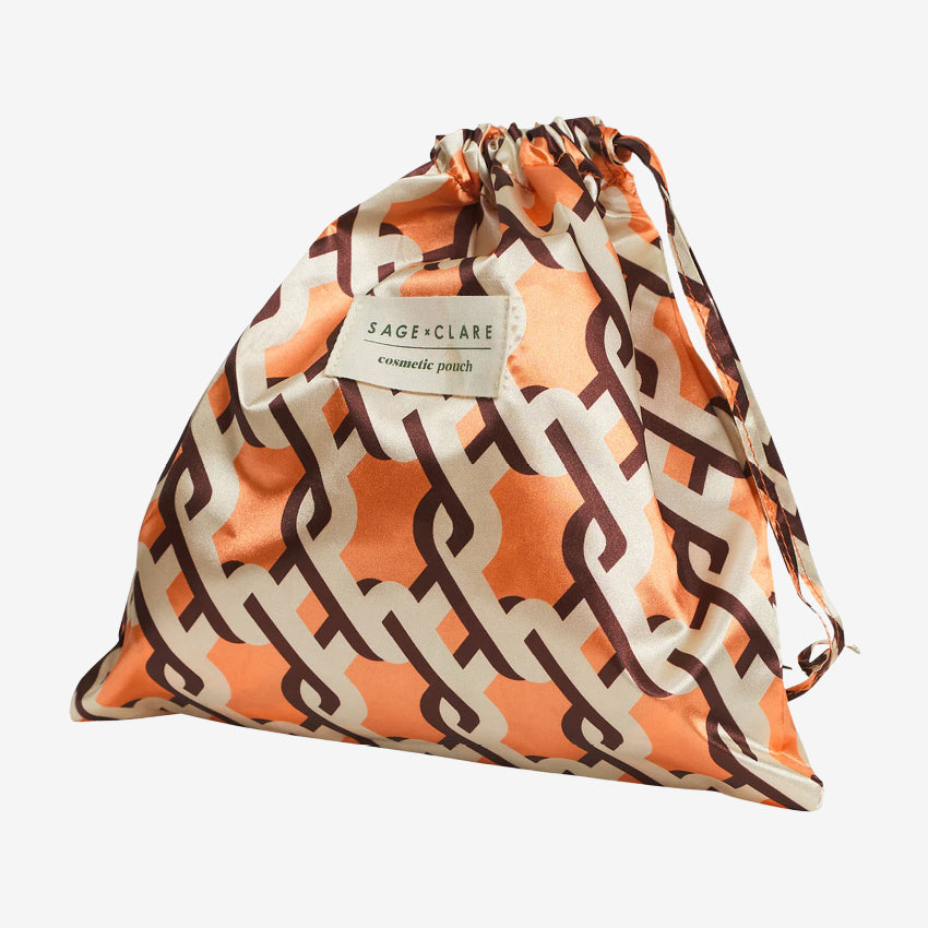 The bag for the Sage x Clare Delphine Cosmetic Pouch in Vivid Coral on a grey background