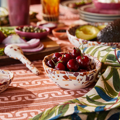 A Sage x Clare Billie Bowl in Nougat Terrazzo with cherries in it on a table.