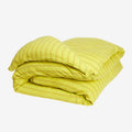 The Sage x Clare Nadine Linen Duvet Cover in Olive folded on a blank background