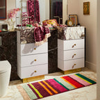 The Sage x Clare Corinne Bath Runner in front of a bathroom vanity