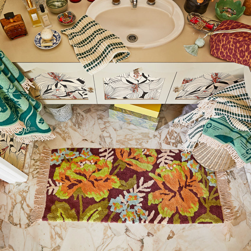 The Sage x Clare Margot Bath Runner in front of a bathroom vanity