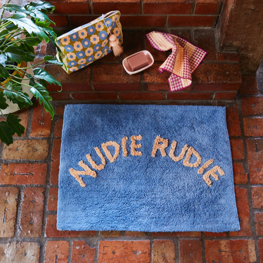 The Sage x Clare Nudie Rudie Bath Mat in Dahlia on a brick floor