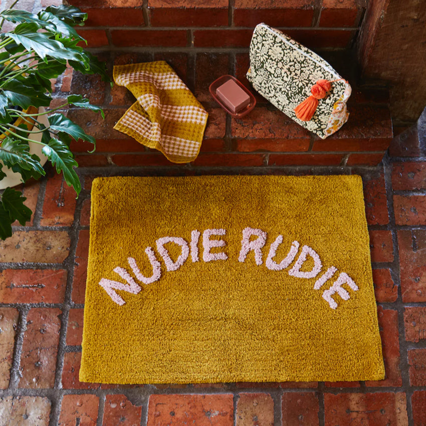 The Sage x Clare Nudie Rudie Bath Mat in Pear on a brick floor