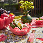 The Sage x Clare Petal Bowl in Plum with avocados in it on a table setting