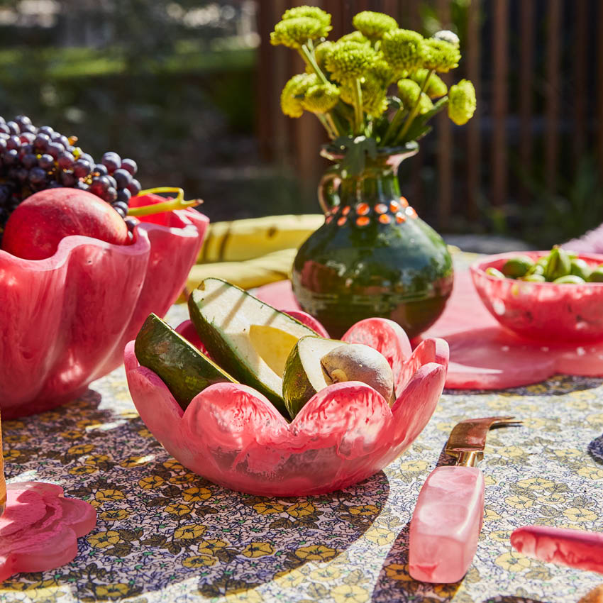 The Sage x Clare Petal Bowl in Plum with avocados in it on a table setting