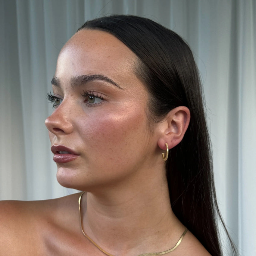 The Silver Linings Collective Navy Hoops in Gold on a model