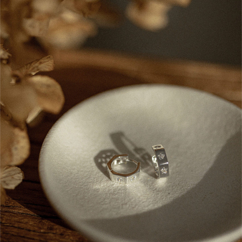 The Silver Linings Collective Whistledown Hoops in Silver on a textured bowl