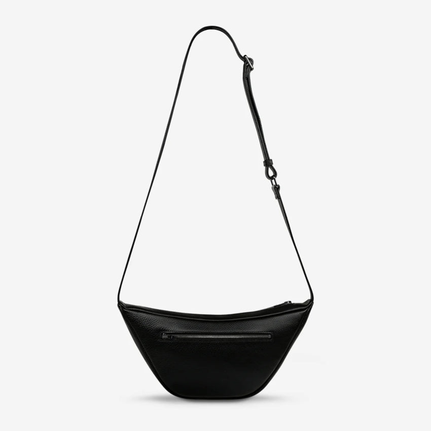 A back view of the Status Anxiety Glued To You Bag in Black on a grey background