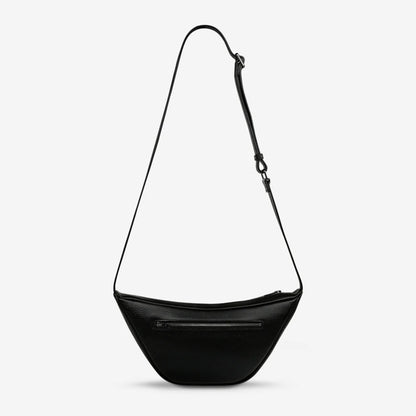 A back view of the Status Anxiety Glued To You Bag in Black on a grey background