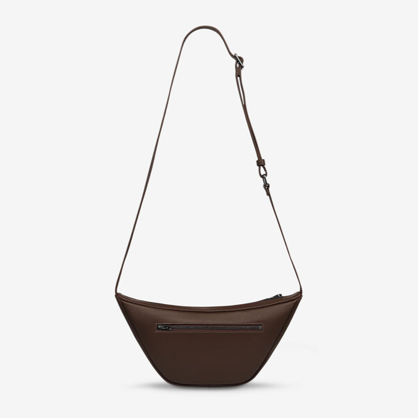 A back view of the Status Anxiety Glued To You Bag in Cocoa on a grey background
