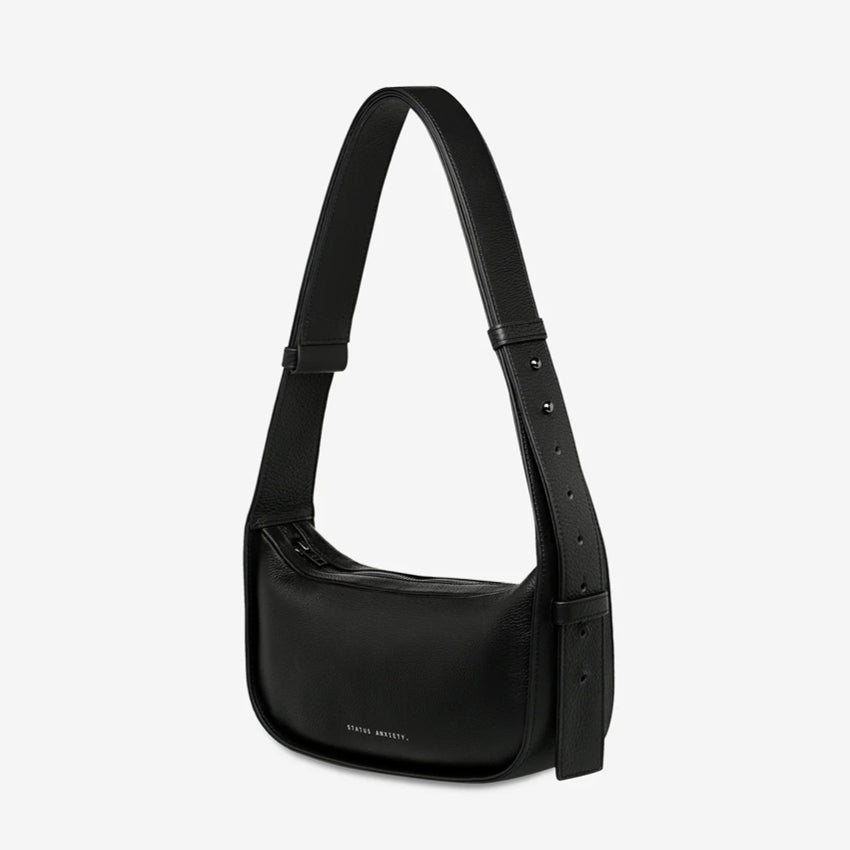 A side view of the Status Anxiety Haven Bag in Black on a grey background