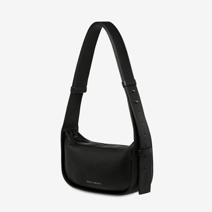 A side view of the Status Anxiety Haven Bag in Black on a grey background