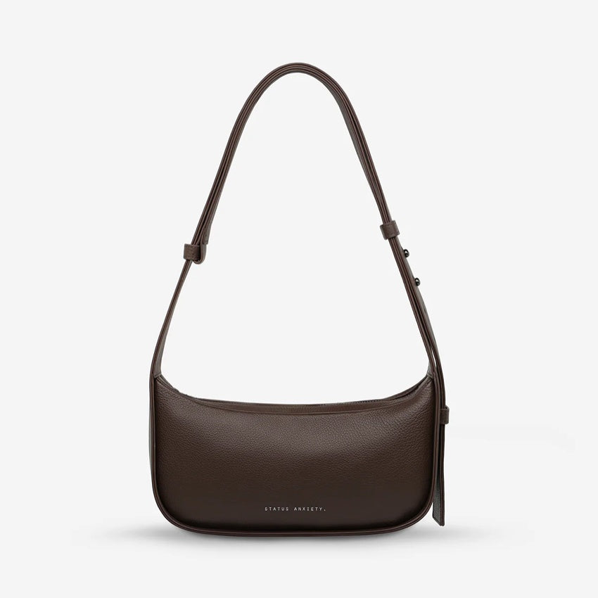The Status Anxiety Haven Bag in Cocoa on a grey background