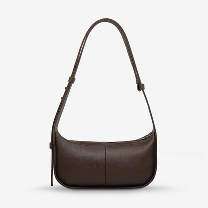 A back view of the Status Anxiety Haven Bag in Cocoa on a grey background