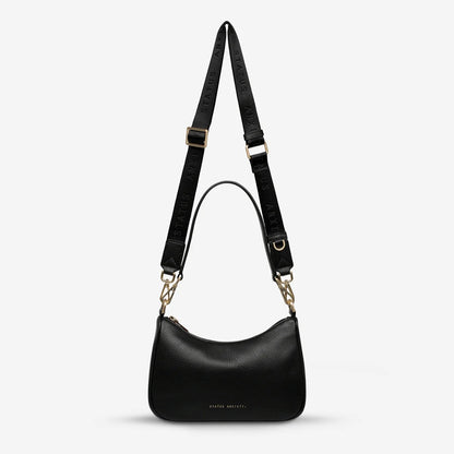 The Status Anxiety Look Both Ways in Black and Brush Gold on a blank background 