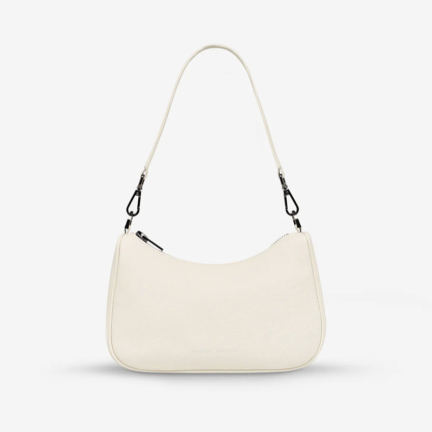The Status Anxiety Look Both Ways Bag in Chalk with just the short strap on a grey background
