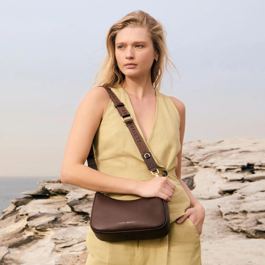 The Status Anxiety Look Both Ways in Cocoa and Brush Gold on a models shoulder with crossbody strap