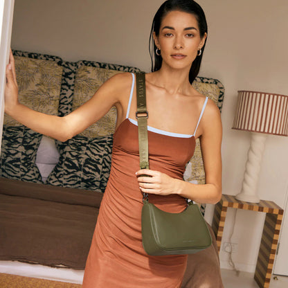 The Status Anxiety Look Both Ways Bag in Khaki crossbody on a model in a house