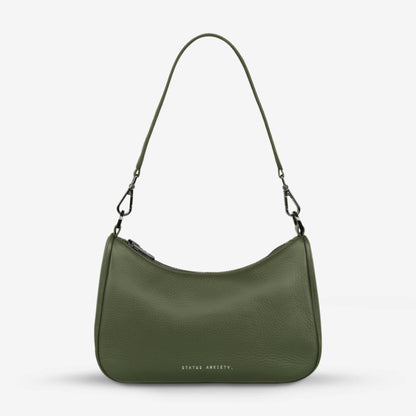 The Status Anxiety Look Both Ways Bag in Khaki with just the shoulder strap on on a grey background