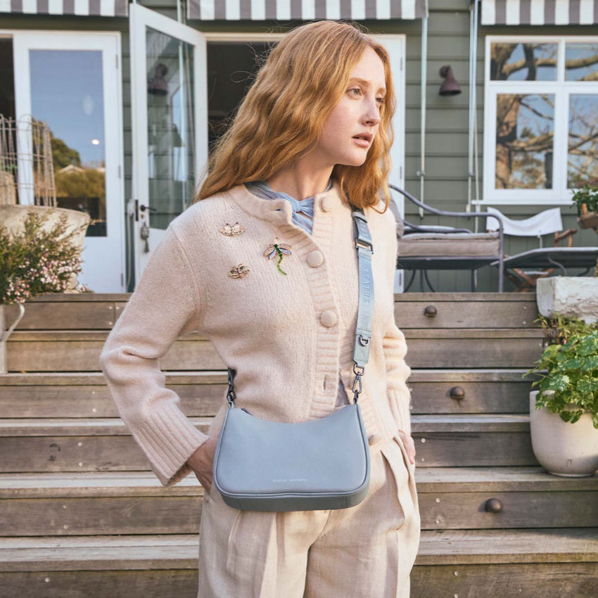 A model wearing the Status Anxiety Look Both Ways in Powder Blue with the long webbed strap