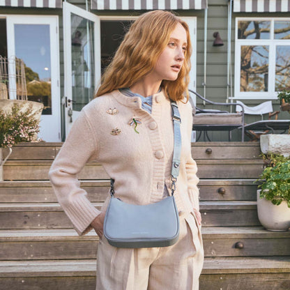A model wearing the Status Anxiety Look Both Ways in Powder Blue with the long webbed strap
