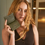 A model holding the open Status Anxiety Lumen Wallet in Khaki up